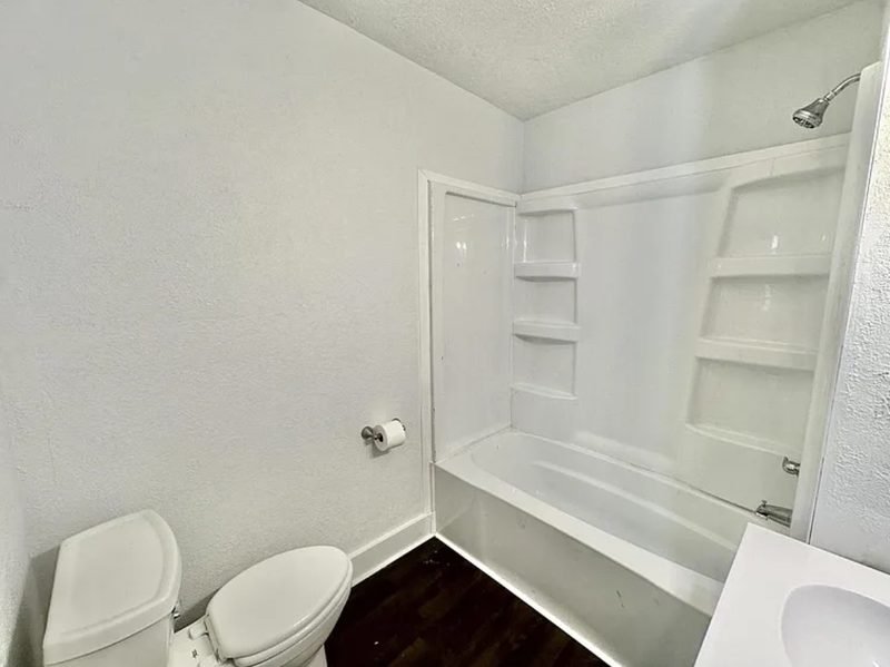 Bathroom after: new tub surround, new toilet and fresh white walls